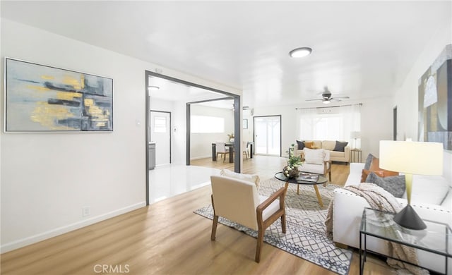 living room featuring light hardwood / wood-style floors and ceiling fan