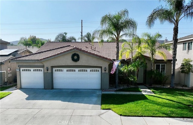 mediterranean / spanish-style house with a front yard and a garage