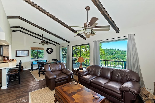 living room with dark wood-type flooring, ceiling fan, a wealth of natural light, and vaulted ceiling with beams