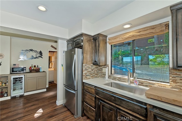 kitchen featuring stainless steel appliances, tasteful backsplash, dark hardwood / wood-style flooring, and beverage cooler