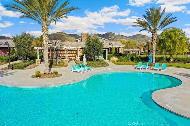 view of swimming pool with a pergola, a mountain view, and a patio