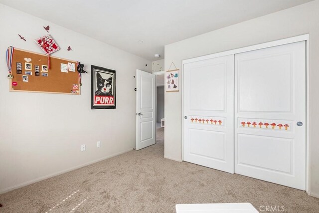 unfurnished bedroom featuring light colored carpet and a closet