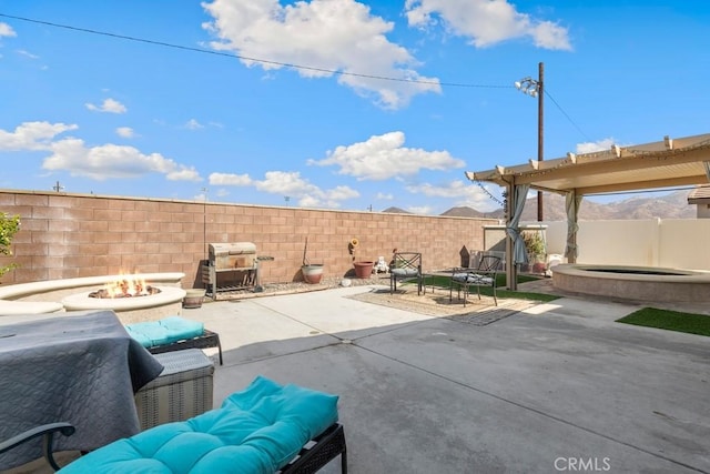 view of patio with an outdoor fire pit, a hot tub, and a grill