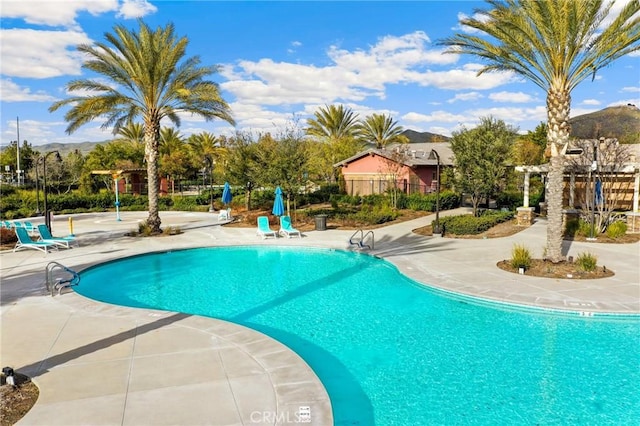 view of pool with a mountain view and a patio