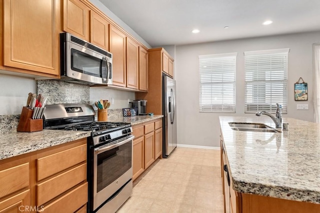 kitchen with light stone countertops, sink, and stainless steel appliances