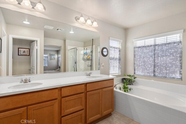 bathroom featuring vanity, tile patterned flooring, and shower with separate bathtub