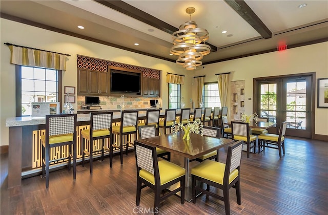 dining area featuring dark wood-type flooring, beam ceiling, and french doors