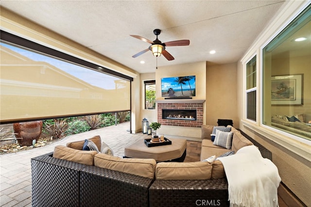 sunroom / solarium featuring a brick fireplace and ceiling fan