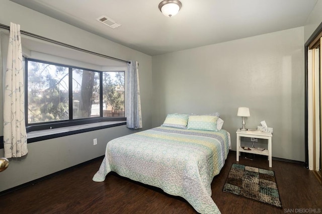 bedroom with dark hardwood / wood-style flooring