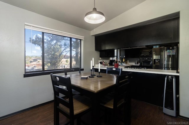 dining area featuring dark hardwood / wood-style floors and vaulted ceiling