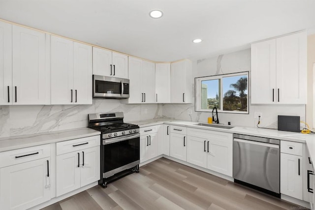 kitchen featuring appliances with stainless steel finishes, white cabinetry, and sink