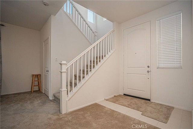 foyer entrance featuring light colored carpet