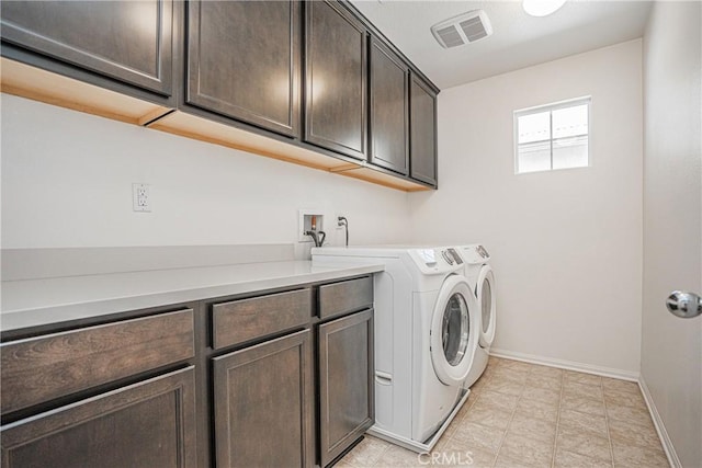 clothes washing area with washing machine and clothes dryer and cabinets