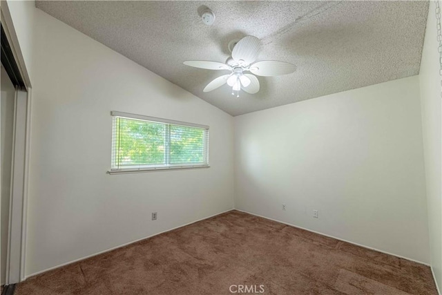 spare room with a textured ceiling, carpet floors, ceiling fan, and lofted ceiling