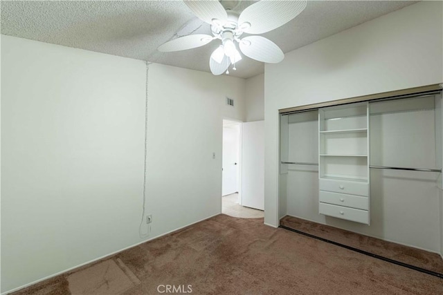 unfurnished bedroom with a textured ceiling, ceiling fan, light carpet, and a closet