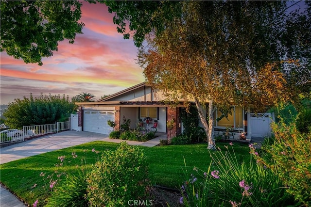 view of front of home with a garage and a lawn