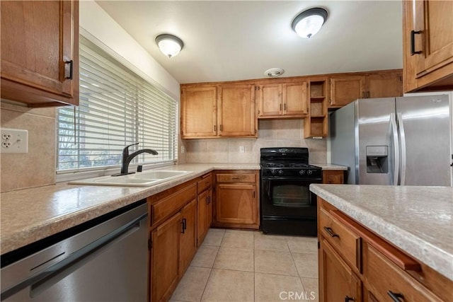 kitchen featuring decorative backsplash, sink, light tile patterned floors, and stainless steel appliances