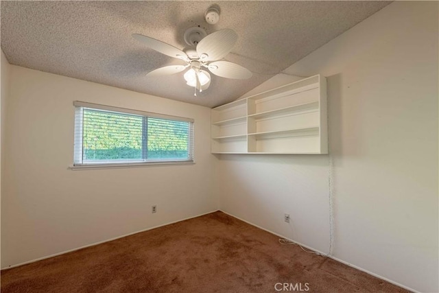 spare room featuring lofted ceiling, ceiling fan, carpet floors, and a textured ceiling