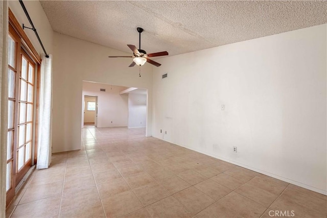 tiled empty room featuring ceiling fan, a healthy amount of sunlight, and a textured ceiling