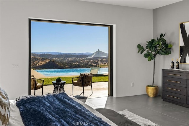 tiled bedroom with a water and mountain view and multiple windows