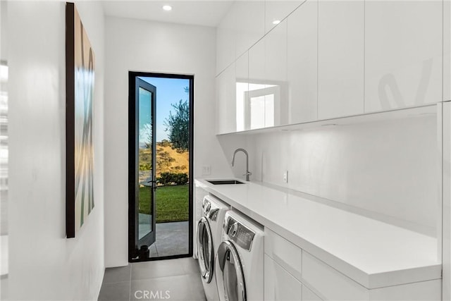laundry room featuring a sink, washer and clothes dryer, cabinet space, and plenty of natural light