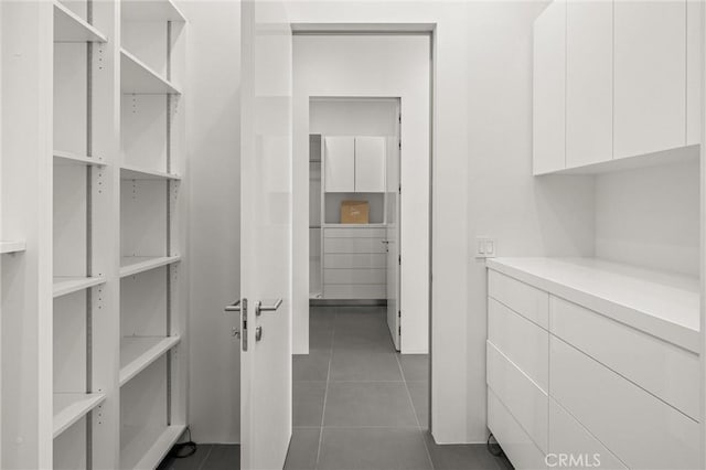 walk in closet with dark tile patterned floors