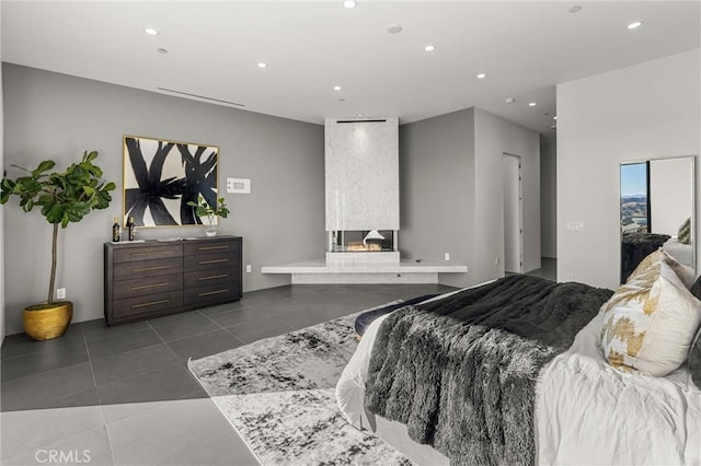 bedroom featuring a fireplace and dark tile patterned flooring