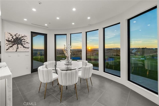 dining space with dark tile patterned flooring and recessed lighting