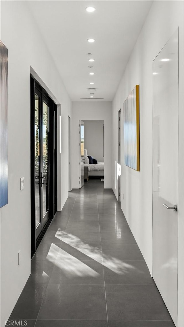 hallway with dark tile patterned flooring and french doors