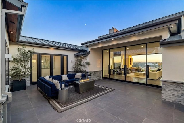 patio terrace at dusk featuring an outdoor living space with a fire pit