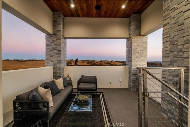 balcony at dusk featuring an outdoor hangout area