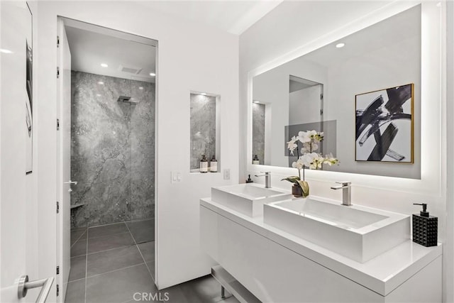 bathroom featuring tile patterned flooring, vanity, and tiled shower