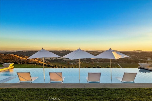 view of pool at dusk