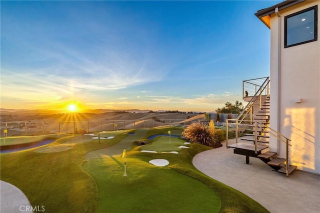 view of home's community with stairs, golf course view, and fence