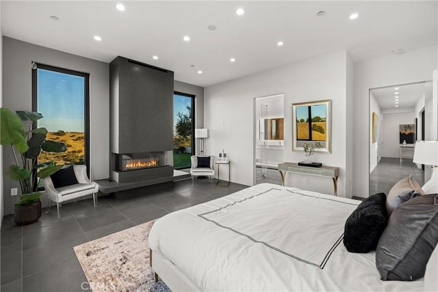 tiled bedroom featuring ensuite bathroom and a fireplace