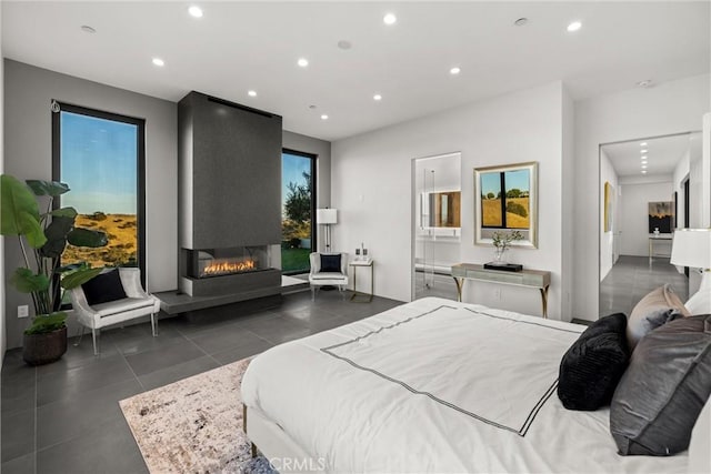 tiled bedroom with connected bathroom, recessed lighting, and a large fireplace