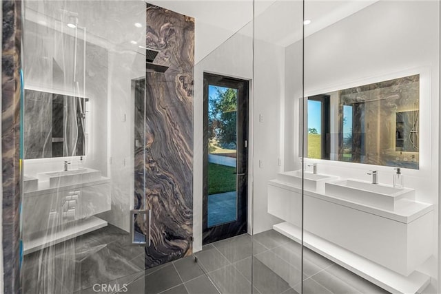 full bathroom featuring tile patterned floors, double vanity, a marble finish shower, and a sink
