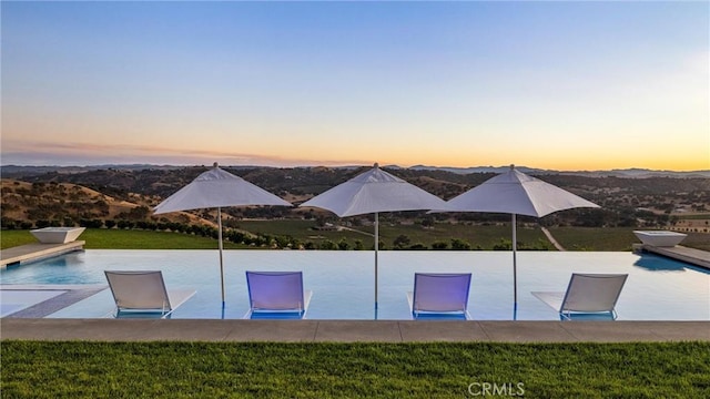 view of pool at dusk