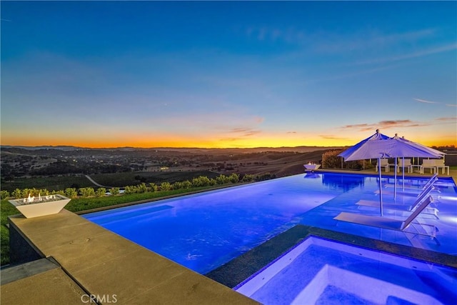 outdoor pool with a patio area and an in ground hot tub