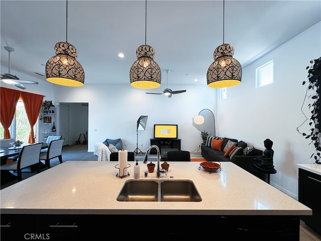 kitchen with lofted ceiling, sink, an island with sink, and pendant lighting