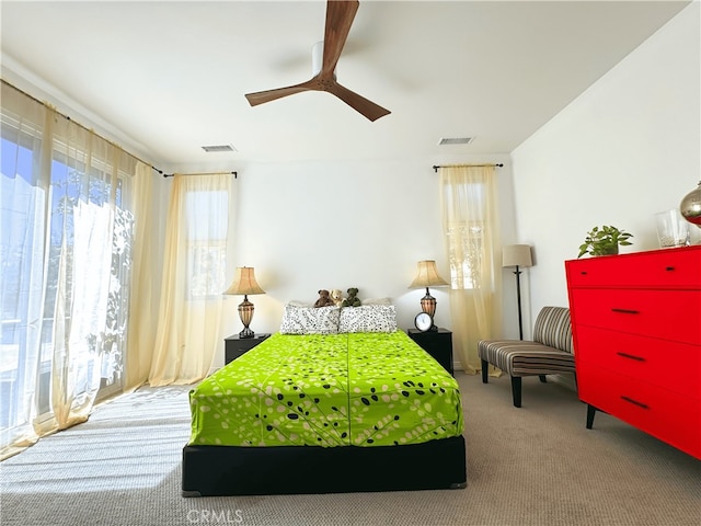 carpeted bedroom featuring multiple windows and ceiling fan