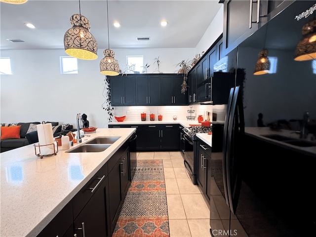 kitchen featuring sink, black appliances, decorative backsplash, and decorative light fixtures