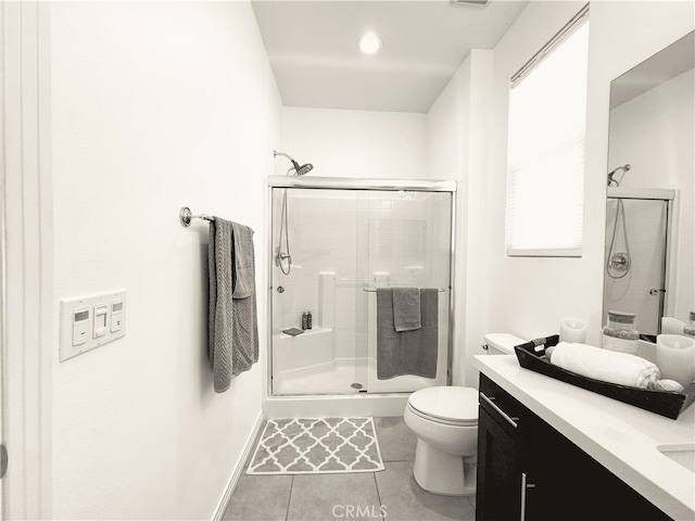 bathroom featuring vanity, toilet, a shower with shower door, and tile patterned flooring