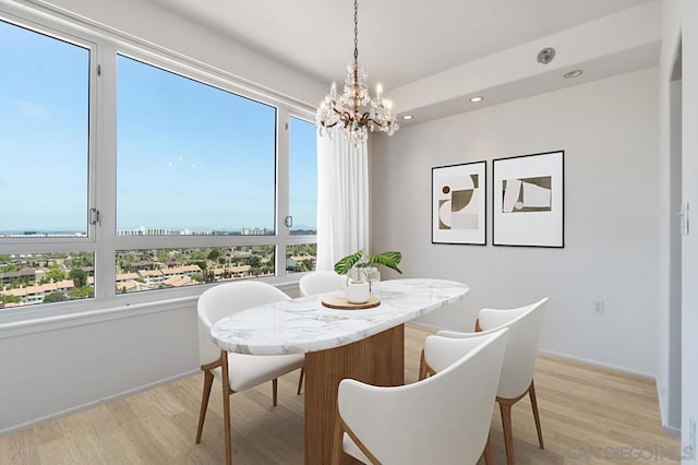 dining room with a notable chandelier, light hardwood / wood-style flooring, and plenty of natural light