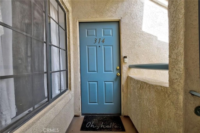 entrance to property featuring stucco siding