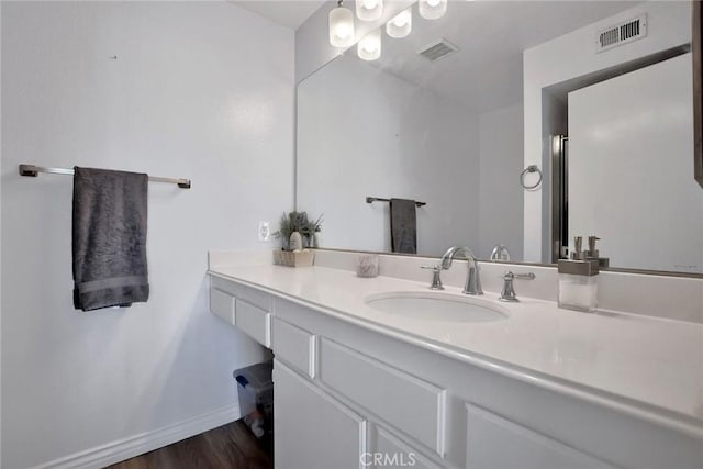 bathroom with visible vents, baseboards, wood finished floors, and vanity