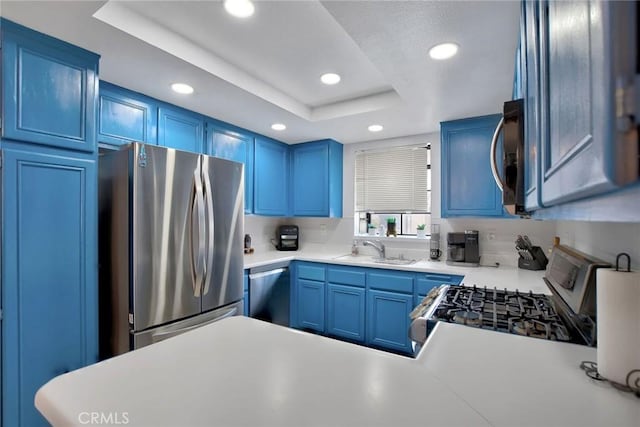kitchen featuring stainless steel appliances, blue cabinetry, recessed lighting, and a sink