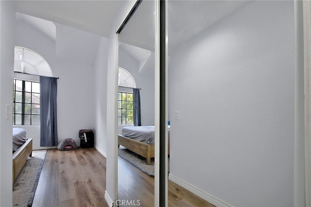 bedroom featuring light hardwood / wood-style floors and vaulted ceiling