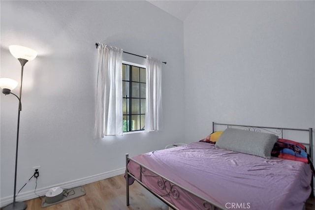 bedroom with light hardwood / wood-style floors and vaulted ceiling