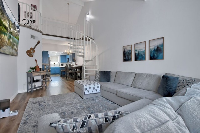 living room with a chandelier, hardwood / wood-style floors, and high vaulted ceiling